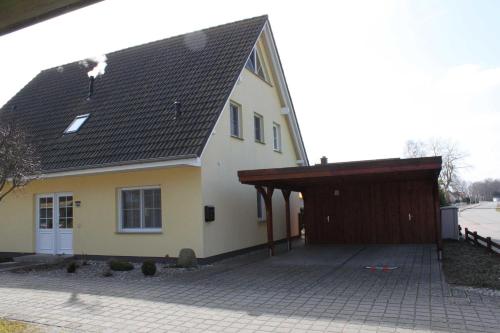 卡尔斯哈根Fewo Sanddorn_BOBE的黄色的房子,设有车库和棕色的屋顶