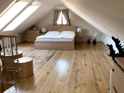 比尔森Sv. Petr (St. Peter)的阁楼卧室配有1张床,铺有木地板。