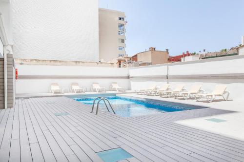 埃尔阿雷纳尔格拉西亚酒店的一座带躺椅的建筑屋顶上的游泳池