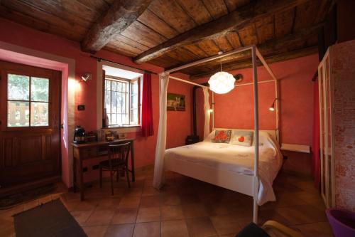 卡尼洛瑞维拉la vecchia casa rosa的一间卧室配有一张天蓬床和一张书桌