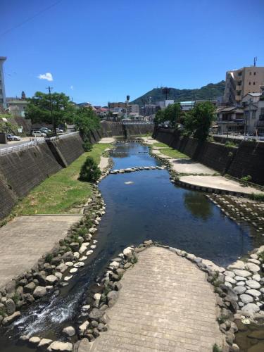 长崎Wagyu hostel nedoko的河的一边有岩石