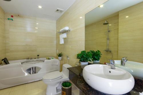 Vu Xa芳映酒店的带浴缸、盥洗盆和卫生间的浴室