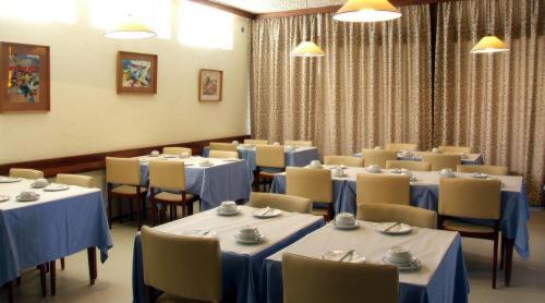 拉戈斯里奥马酒店的一间配备有桌椅及蓝桌布的用餐室
