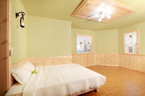西归浦市甜蜜之盐度假屋的卧室配有白色的床