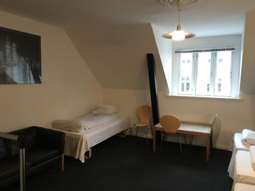 哥本哈根欧洲环球酒店的一间卧室配有一张床、一张桌子和一个窗户。