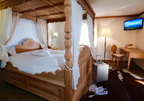 格吕耶尔Hôtel de Ville的一间卧室配有一张带天蓬的大型木床