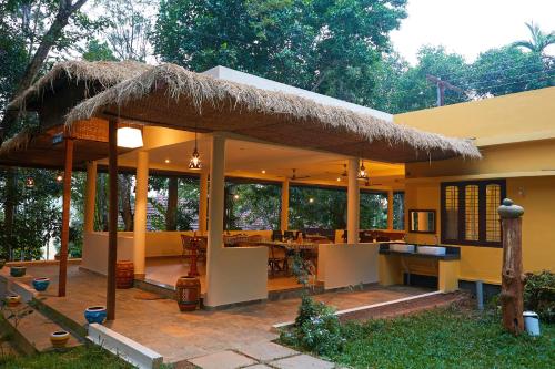 苏丹巴特利Raindrops Resorts的房屋设有茅草屋顶庭院