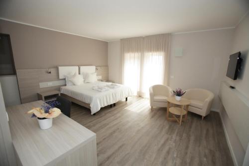 马罗斯蒂卡欧罗巴酒店的酒店客房带一张床、一张桌子和椅子