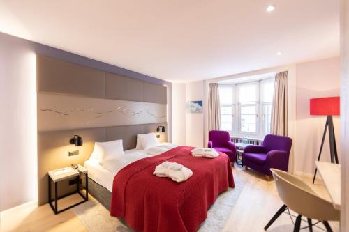 蓬特雷西纳罗萨兹酒店的酒店客房,配有一张床和两张紫色椅子