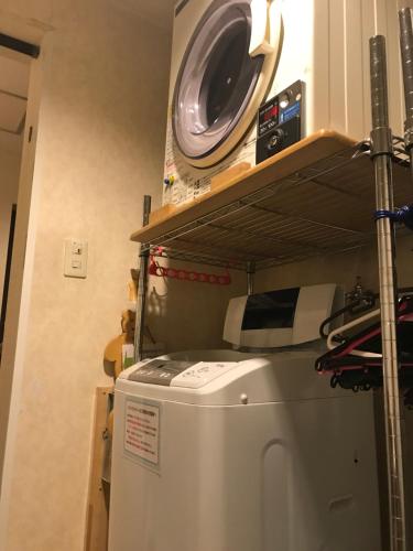 Ichihara五井山商务酒店的厨房的架子上设有洗衣机和烘干机