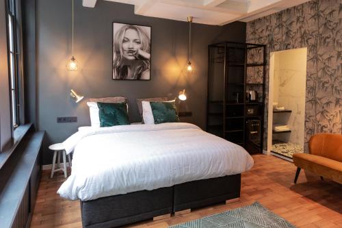 阿姆斯特丹The Blossom House Amsterdam的卧室配有一张白色大床和一把椅子