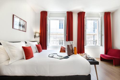 图卢兹阿尔伯特第一酒店的卧室配有一张带红色窗帘的大型白色床