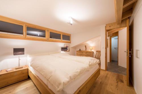 弗利姆斯Casa Alpetta的卧室配有一张白色的大床,铺有木地板