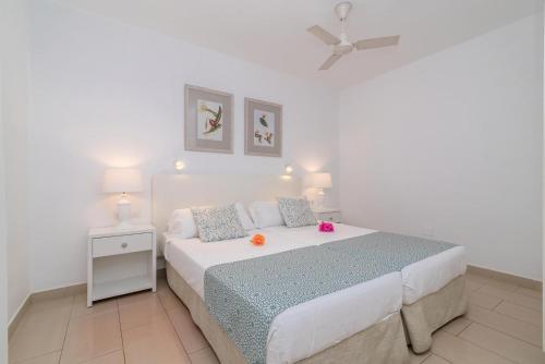 卡门港Apartamentos Parque Tropical en Lanzarote的白色卧室配有一张带吊扇的床