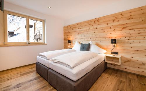 沃瑟姆阿尔伯格Bildegg Appartements的木墙客房的一张床位