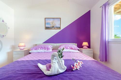 尼亚卢卡Villa Paradise的紫色的床,上面有一对袜子