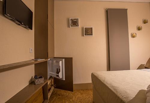 英雄港ALLuar Lodge的配有一张床和一台平面电视的酒店客房
