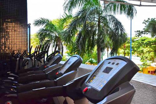 福塔莱萨Landscape Residence by Escala Imóveis的在棕榈树健身房里一排健身自行车