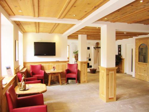 布赖尔齐斯腾帕斯酒店的一间设有红色椅子和平面电视的等候室