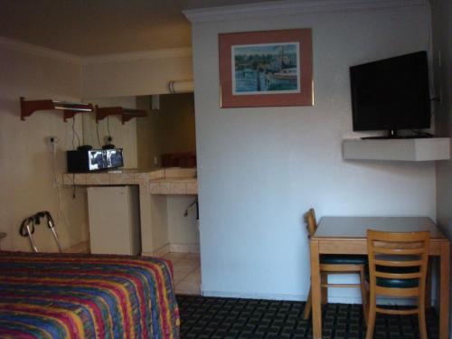 South El Monte美国旅馆的酒店客房设有床、桌子和电视。