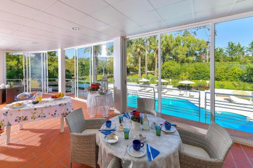 马丁纳弗兰卡Villa del Sole Martina Franca的一间带两张桌子的用餐室和一个游泳池