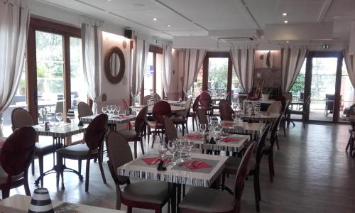 圣克莱芒德里维耶尔蒙彼利埃北欧洲医学公园酒店的餐厅设有白色的桌椅和窗户。