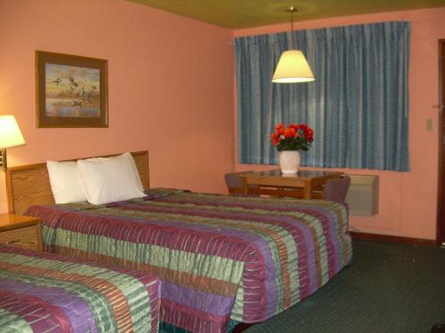 北普拉特83 motel的酒店客房带两张床和花瓶