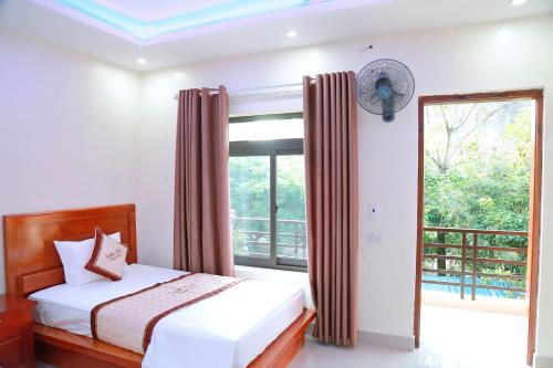 宁平Tam Coc Legend Hotel的一间卧室设有一张床和一个大窗户