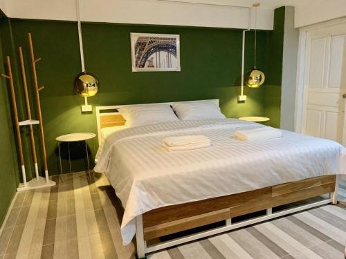 巴色You Empire Hostel & Bar的一间卧室设有一张带绿色墙壁的大床