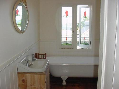 RhyllCaptain Lock's Cottage的带浴缸、水槽和镜子的浴室