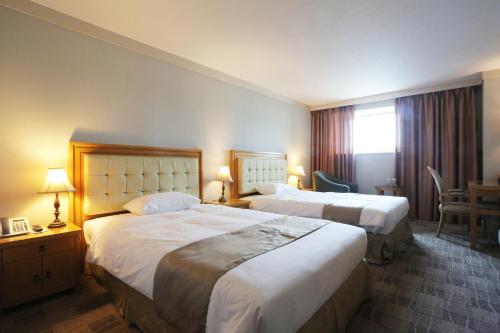 大邱大邱AW酒店的酒店客房设有两张床和窗户。
