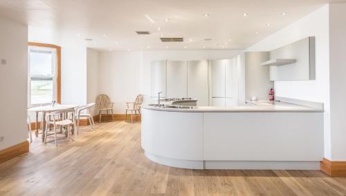 阿尔恩茅斯South View House的厨房配有白色的柜台和桌子