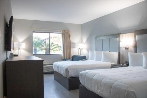 泰比岛Admiral's Inn on Tybee Island的酒店客房设有两张床和窗户。