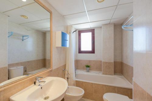 卡尔佩Villas Guzman - Apartamento Coral Beach的浴室配有盥洗盆、卫生间和浴缸。
