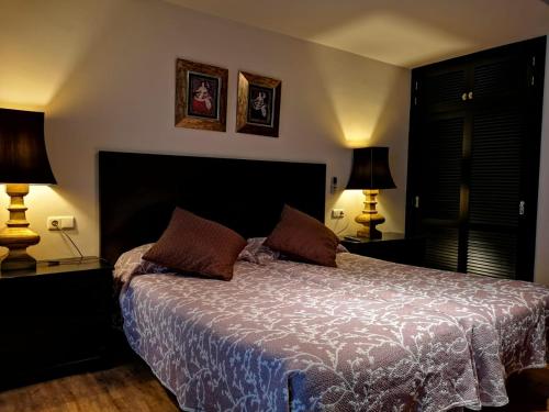 内尔哈三个太阳旅馆的一间卧室配有一张大床和两盏灯