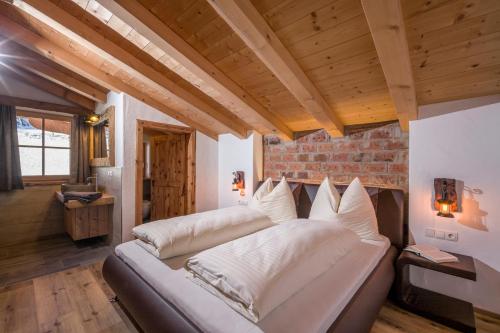 布里克森谷地霍普夫加尔滕Chalet Apartment Obermanzl的木制天花板的客房内的一张大床