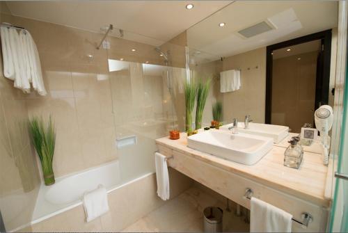 丰沙尔Pestana Madeira Beach Club的浴室配有盥洗盆、浴缸和盥洗盆