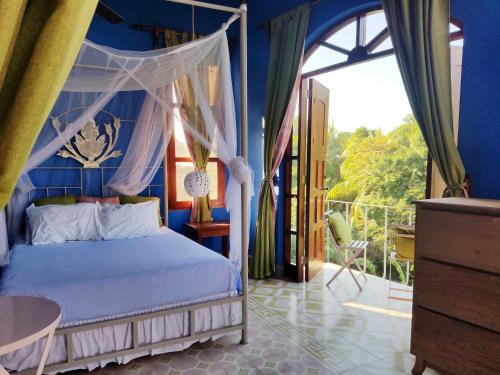 格拉纳达Secret Cottage Granada Nicaragua的一间卧室配有一张蓝色墙壁的床