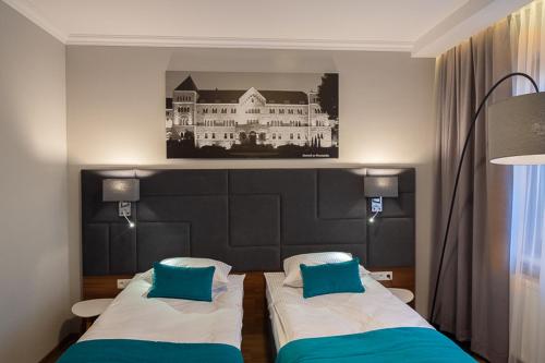 波兹南波兹南中心托帕兹酒店的一间卧室配有两张床,并拥有一栋建筑的照片