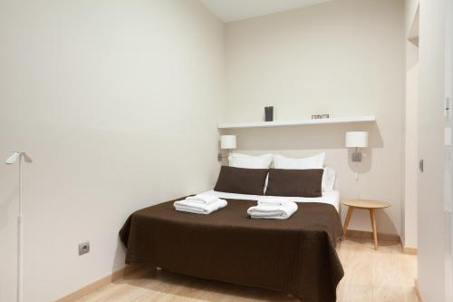 巴塞罗那易兹斯利普博奈旅馆的一间卧室配有一张床,上面有两条毛巾