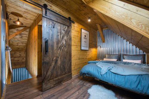 利普托斯基米库拉斯卡尔马公寓的小木屋内一间卧室,设有谷仓门