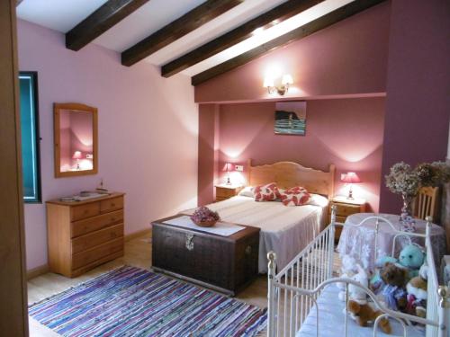里瓦德奥Casa Benito的一间卧室配有一张床、梳妆台和婴儿床。