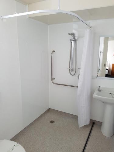 因弗卡吉尔554号莫阿纳阁汽车旅馆的带淋浴和盥洗盆的白色浴室