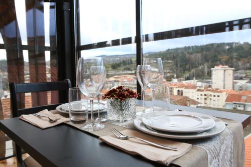 拉梅戈Muralha Charm House的桌子上带玻璃杯和盘子的桌子,享有美景
