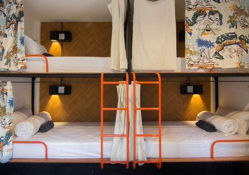 奥南海滩TAN Hostel x Cafe , Aonang Beach的客房内的两张双层床位配有橙子垫