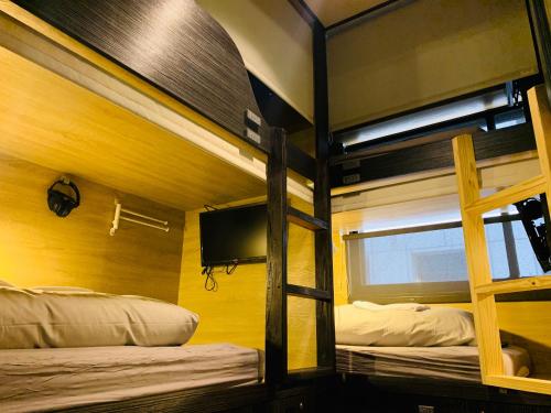 台北WORK INN 北车馆的配有电视的客房内的两张双层床