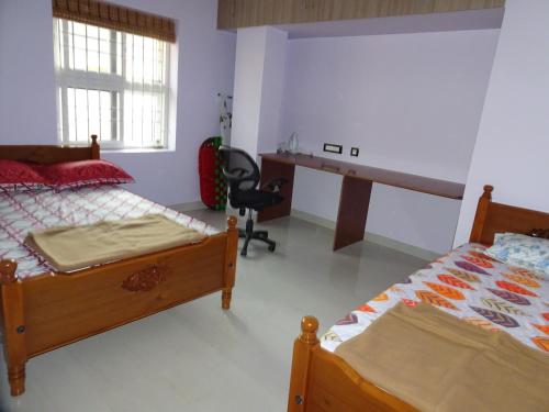 蒂鲁奇奇拉帕利Haritham的一间卧室配有两张床和一张书桌