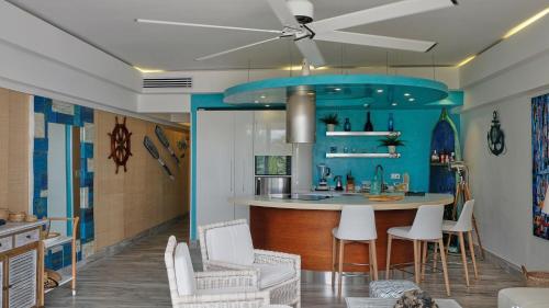 璜多里奥Juan Dolio Costa del Sol的厨房配有蓝色岛屿和白色椅子