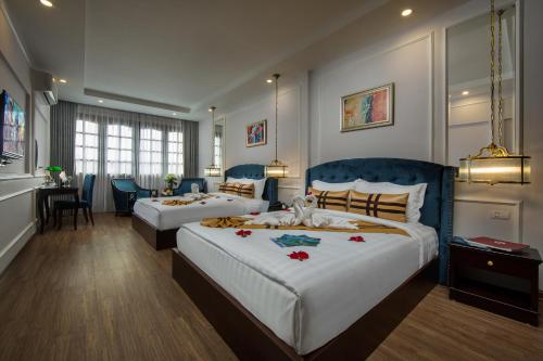 河内S Central Hotel and Spa的酒店客房设有两张床和用餐区。