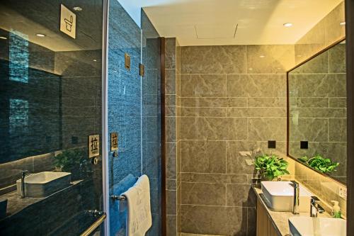 兰州蘭莓精品酒店西客站（兰州中心店）的带淋浴、盥洗盆和镜子的浴室